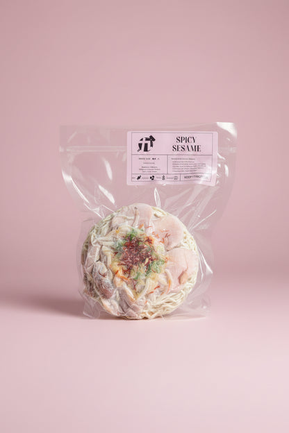 Packaged spicy sesame ramen with visible chicken and vegetables